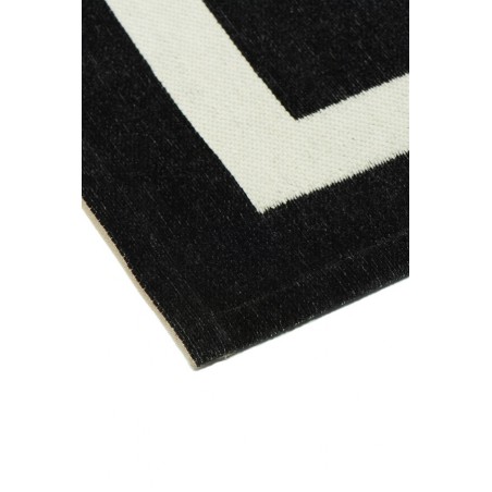 Czarny dywan z białym obrzeżem do salonu